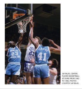 Picture of Jay Bilas #21 scoring a basket as a Duke Student in the 1980s against two UNC players.
